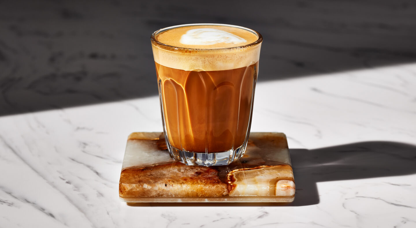 Espresso drink in a glass on a coaster