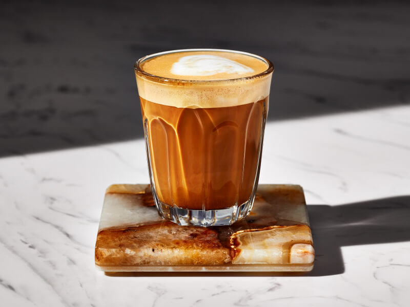 Espresso drink in a glass on a coaster