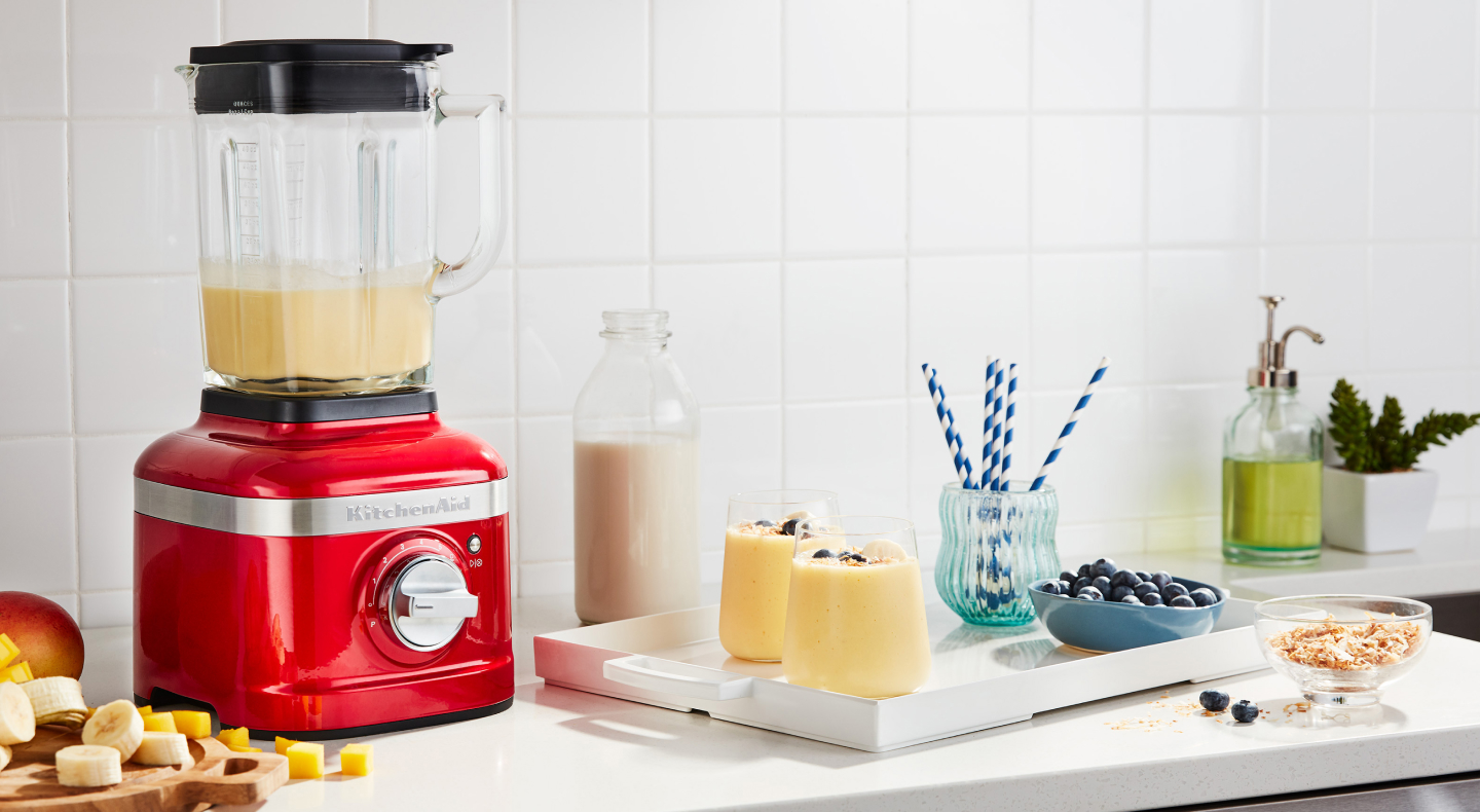 KitchenAid® blender next to tray with frozen fruit drinks