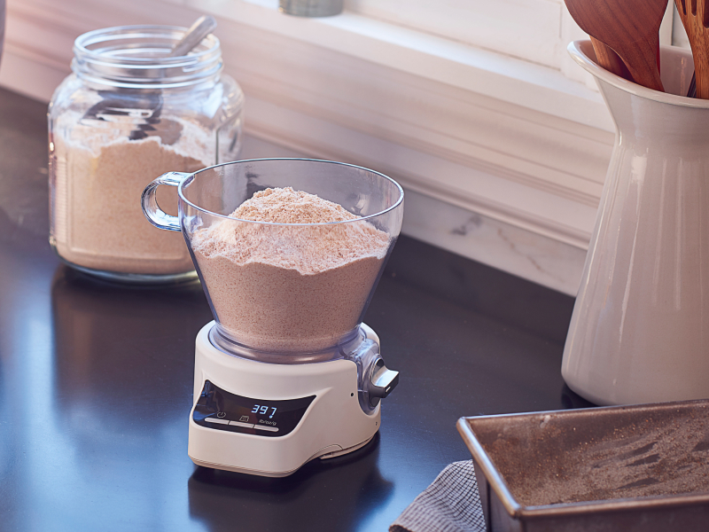 KitchenAid® Sifter + Scale Attachment sitting on countertop full of flour