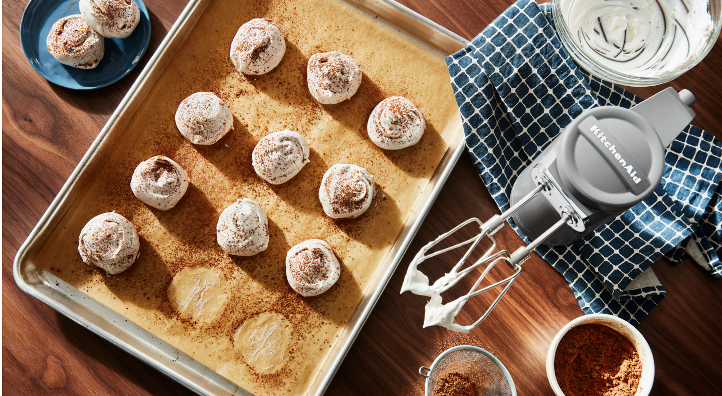 KitchenAid® hand mixer and meringue on a cookie sheet