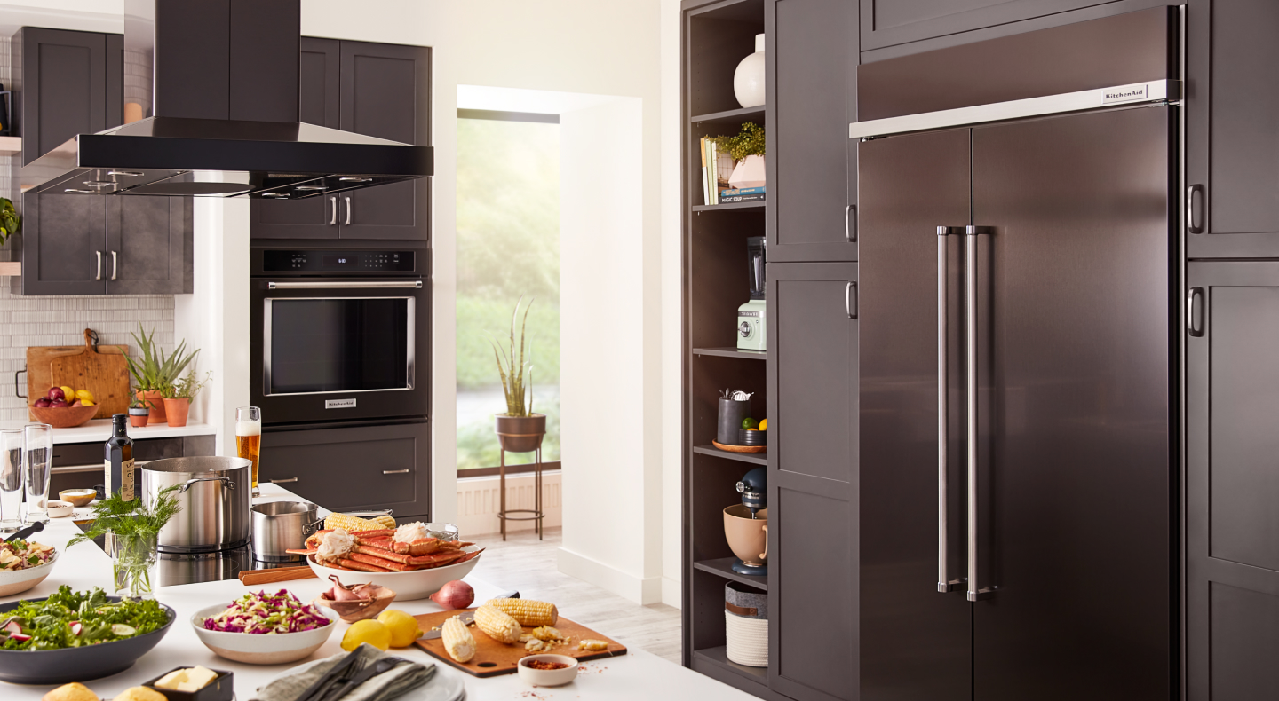 Full view of kitchen with countertop, plates of food and panel-ready appliances