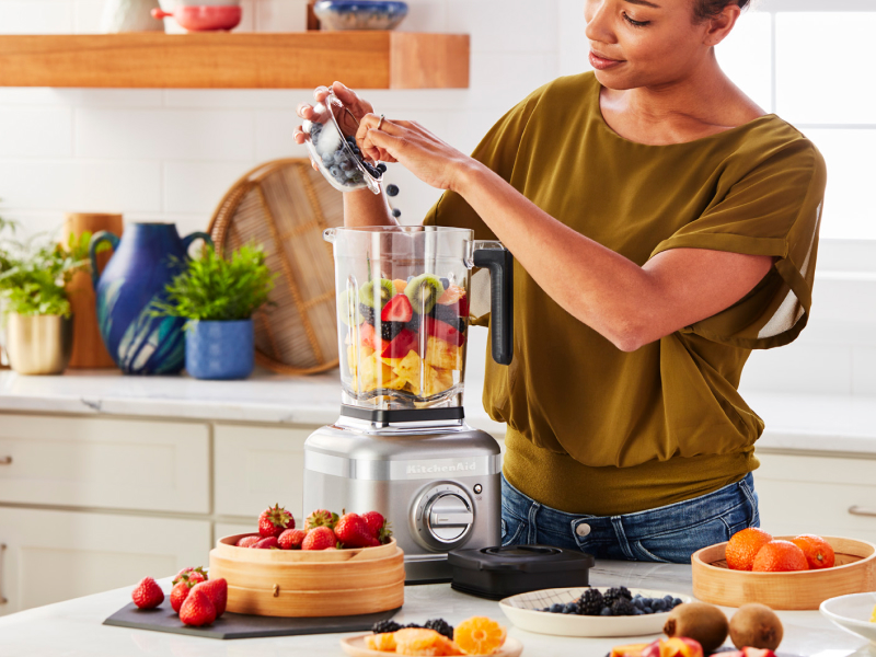 Person adding fruit to a KitchenAid® blender