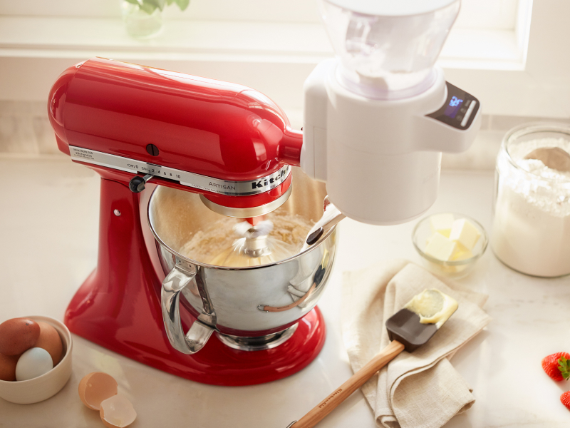 A red KitchenAid® stand mixer amongst various baking ingredients
