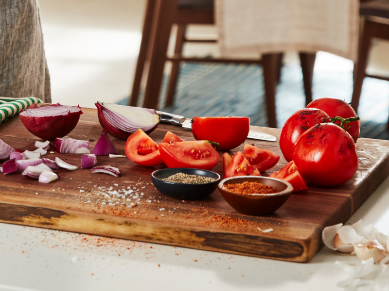 Sliced tomatoes and red onion on a cutting board
