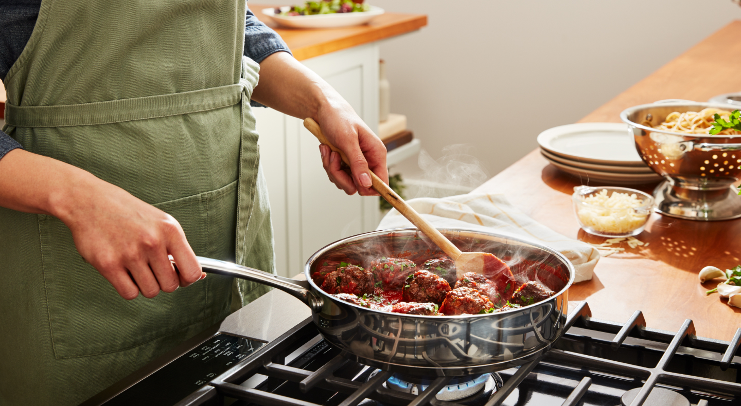 Woman making meatballs on cooktop