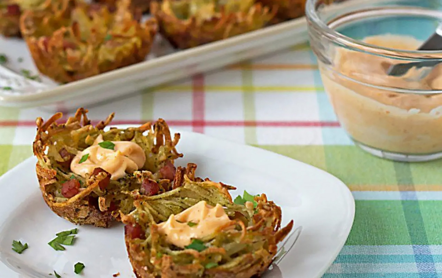 A plate of potato vegetable fritters with an aioli sauce 