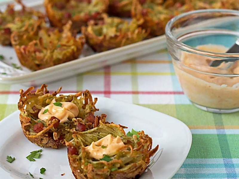 A plate of potato vegetable fritters with an aioli sauce 