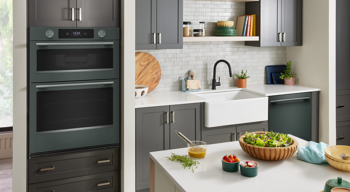 A bright kitchen with grey cabinetry and a KitchenAid® wall oven