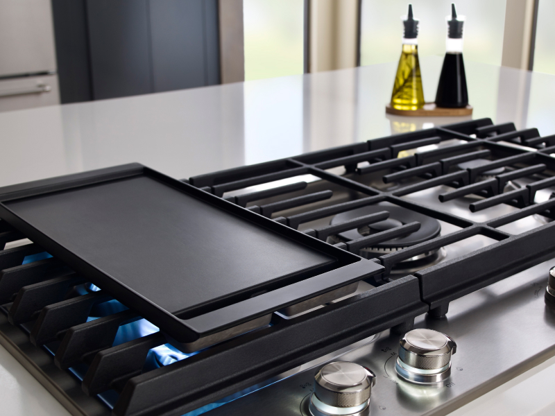 A griddle preheating on a gas stove