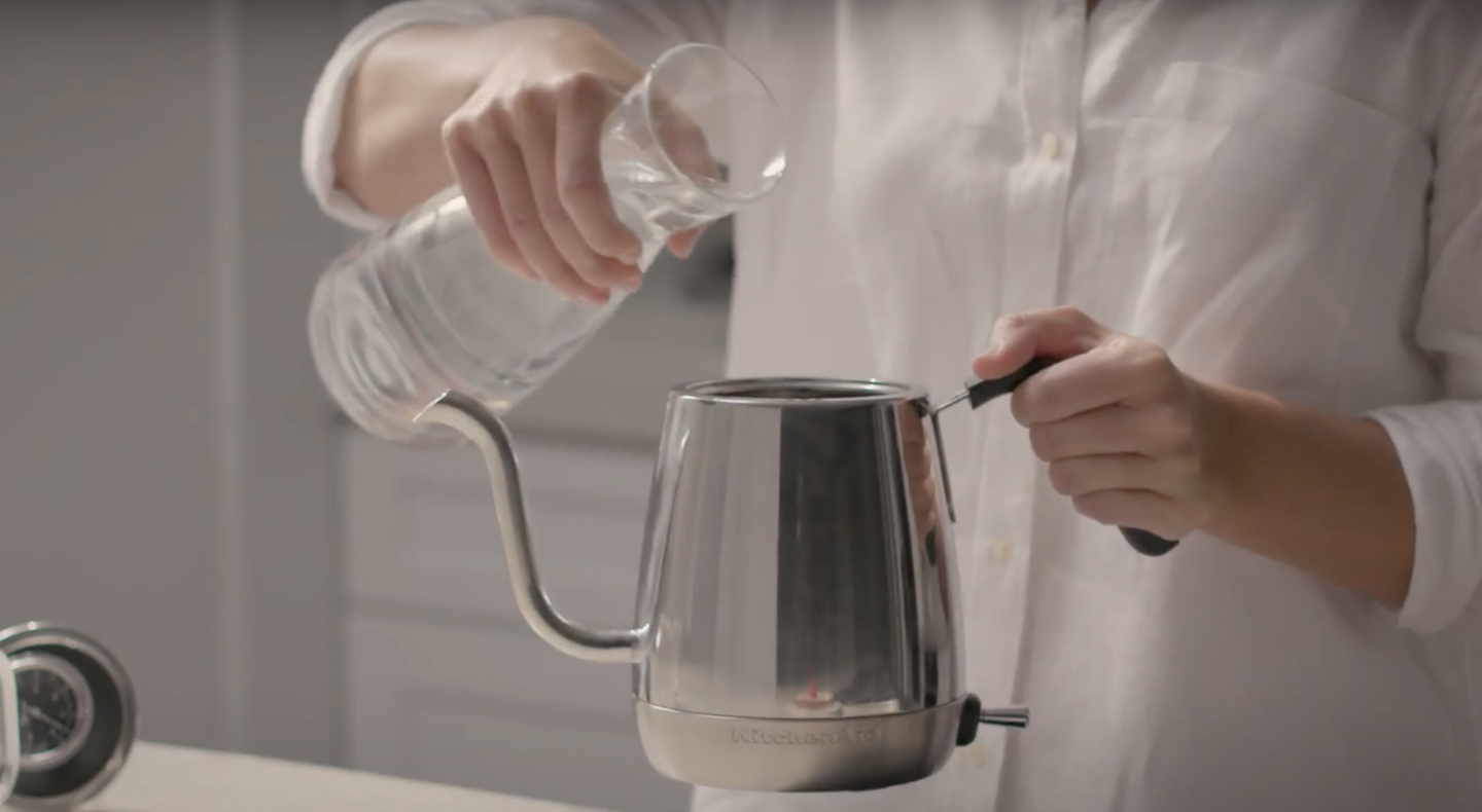 Maker pouring water into stainless steel KitchenAid® gooseneck kettle