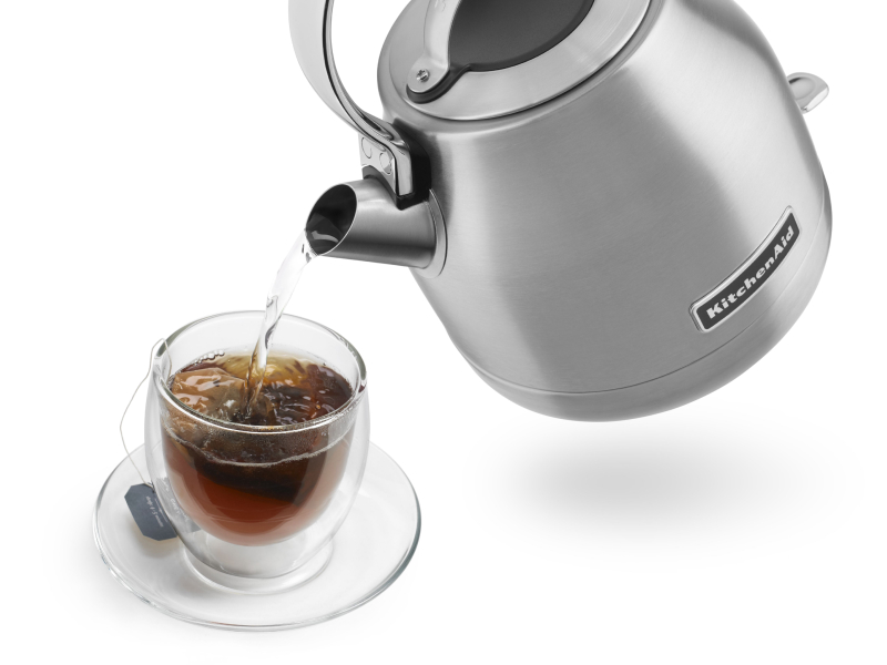 Hot water being poured from KitchenAid® kettle into glass of tea