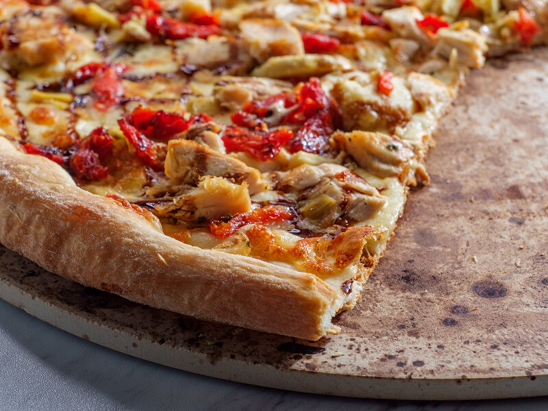 A close-up of a slice of pizza on a pizza stone