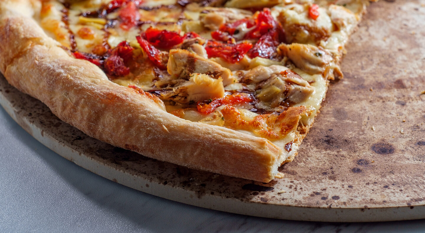 A close-up of a slice of pizza on a pizza stone