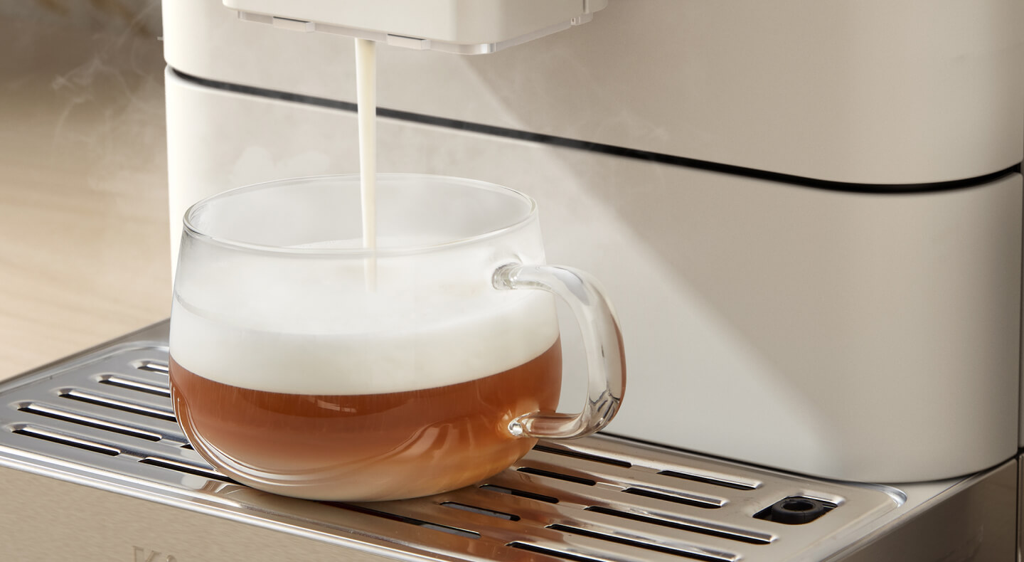 Frothed milk being poured over an espresso beverage
