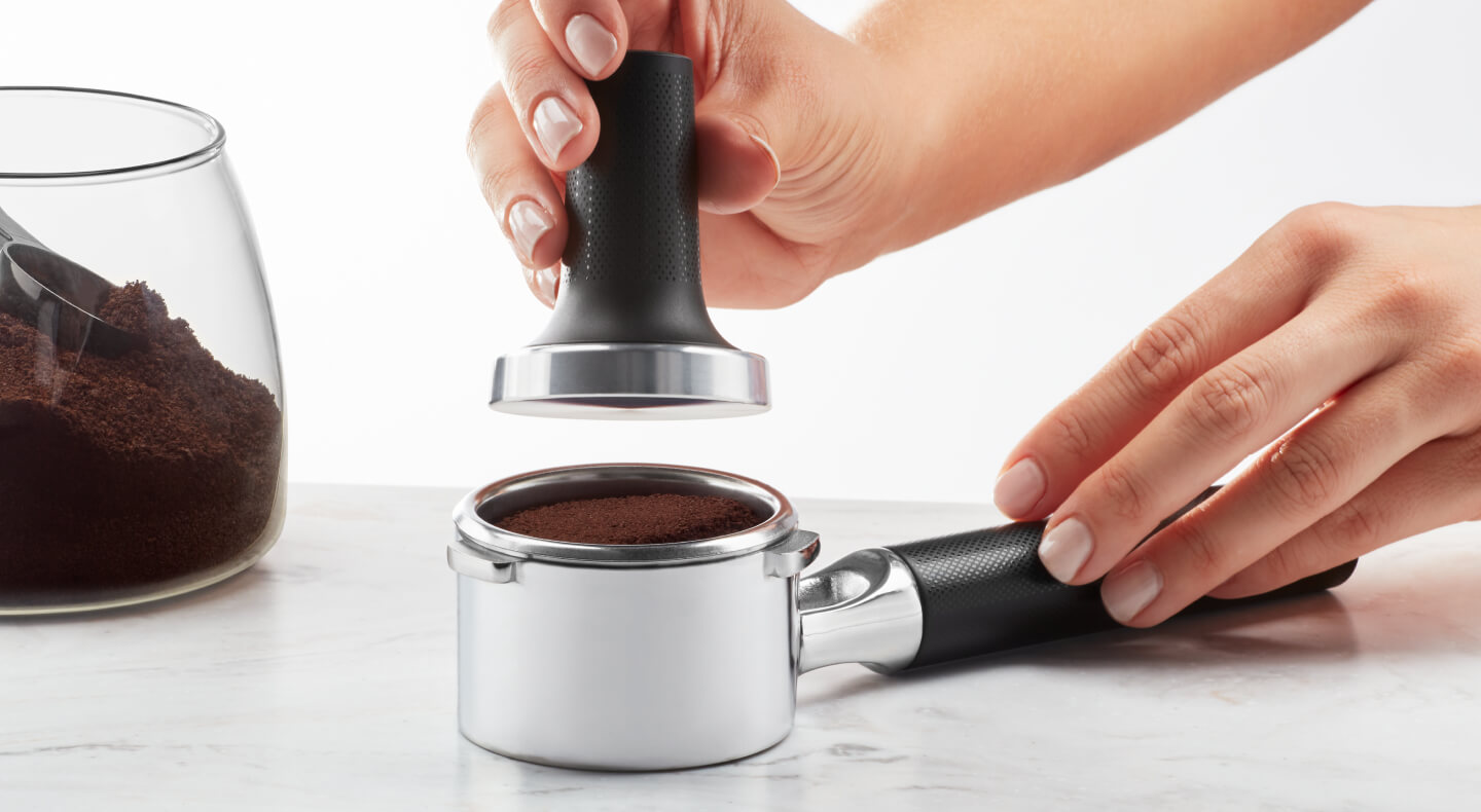 Hand tamping espresso grounds in a portafilter