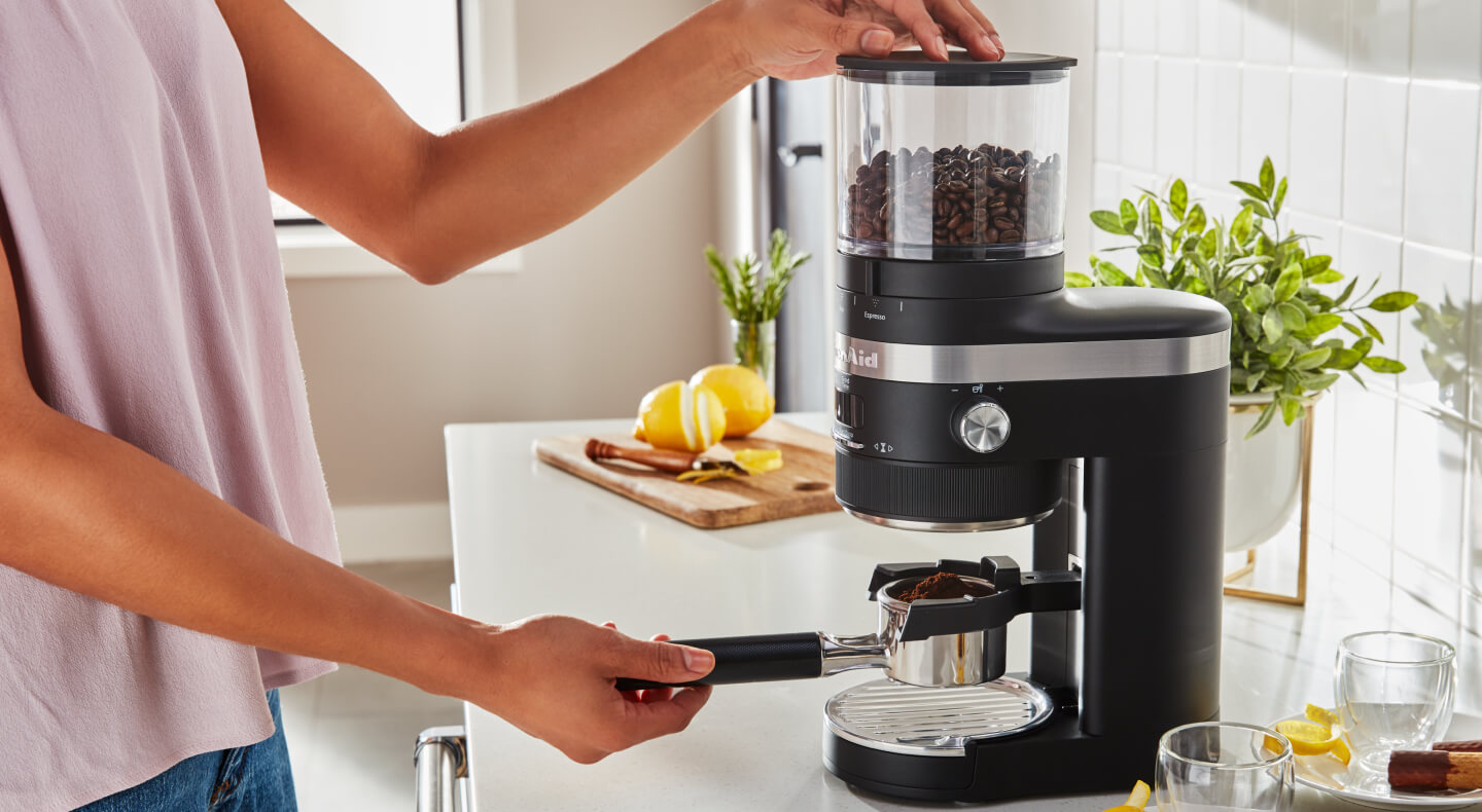 Woman grinding coffee into a portafilter