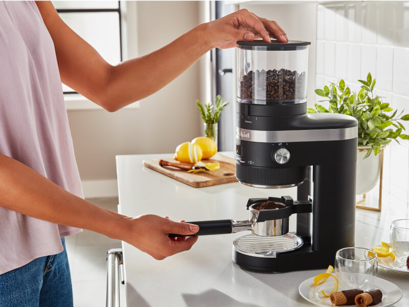 Woman grinding coffee into a portafilter