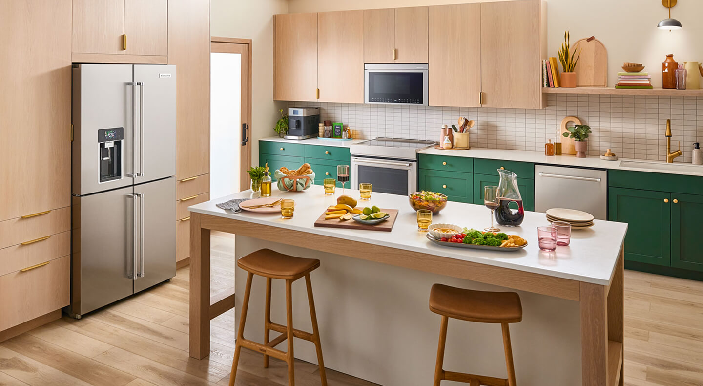 A bright kitchen island with veggie platters and wine on it