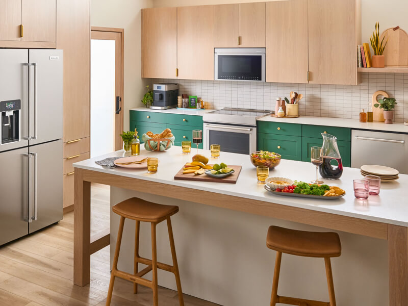 A bright kitchen island with veggie platters and wine on it