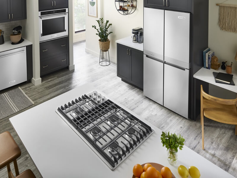 A bright kitchen with an island with a cooktop installed in it