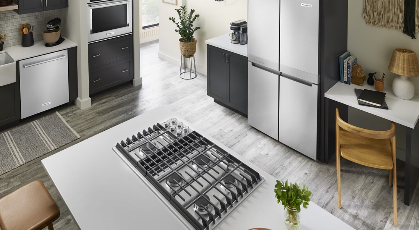 A bright kitchen with an island with a cooktop installed in it