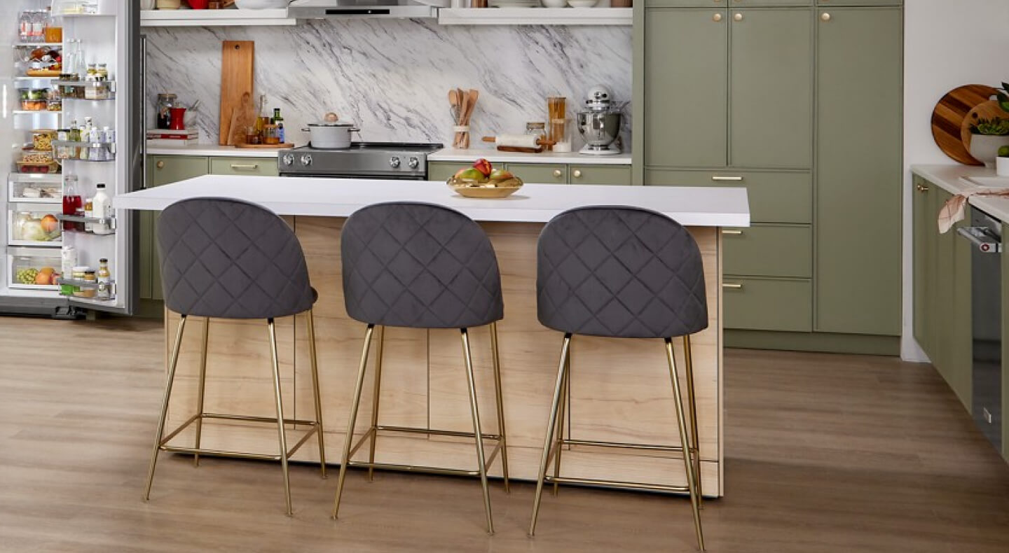 A white-topped kitchen island with three stools