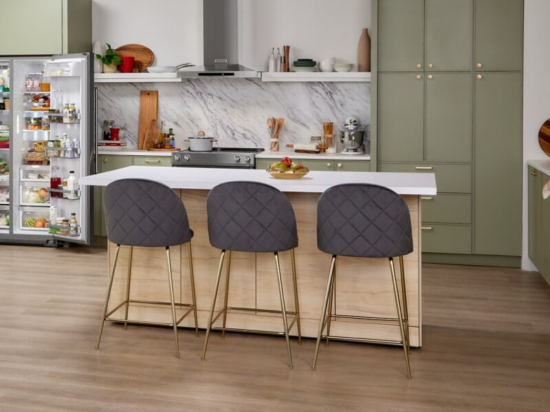 A white-topped kitchen island with three stools