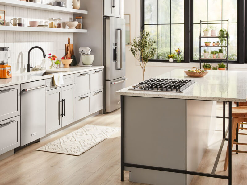 A bright kitchen with an island with a stovetop and stool seating
