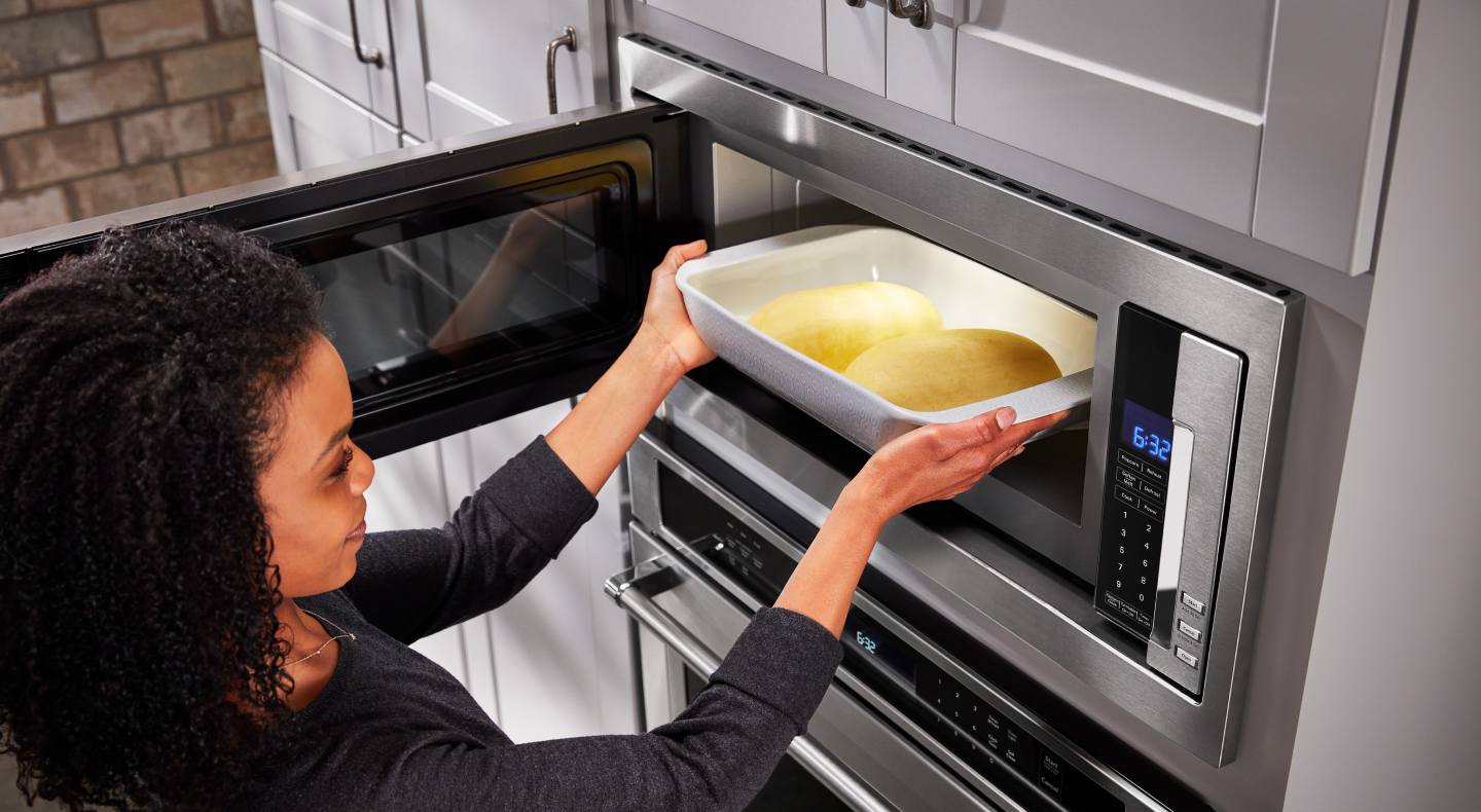Person putting food into microwave