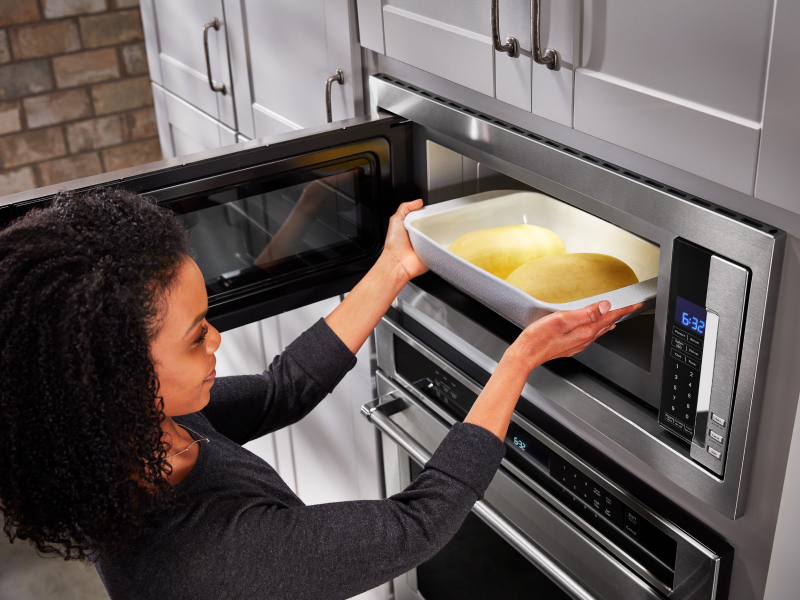 Person putting food into microwave