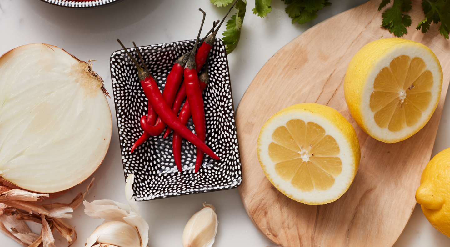 Onions, Chili peppers and lemon on table