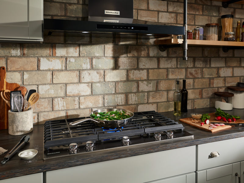 Black KitchenAid® canopy range hood over gas stovetop