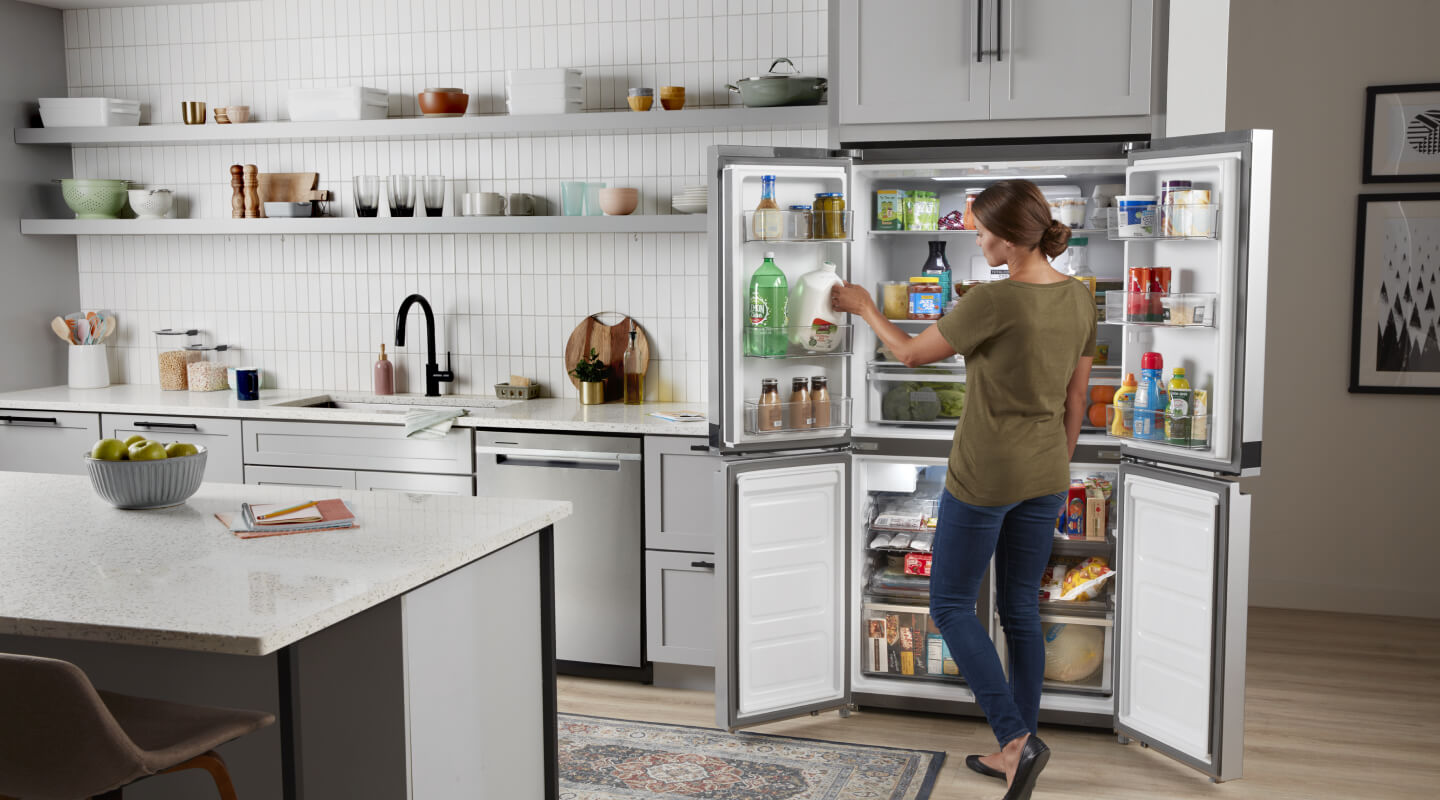 A person organizing a 4-door refrigerator