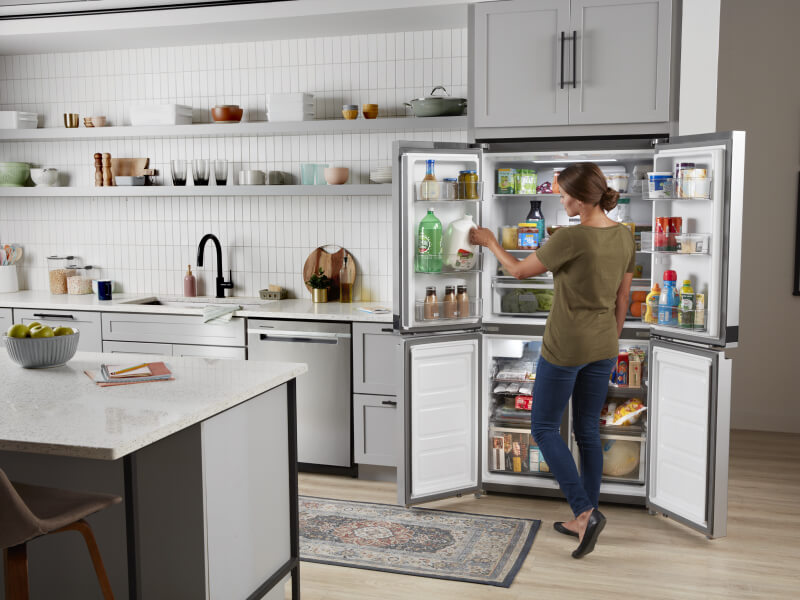 A person organizing a 4-door refrigerator