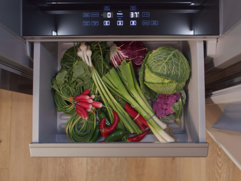 An open produce drawer filled with veggies