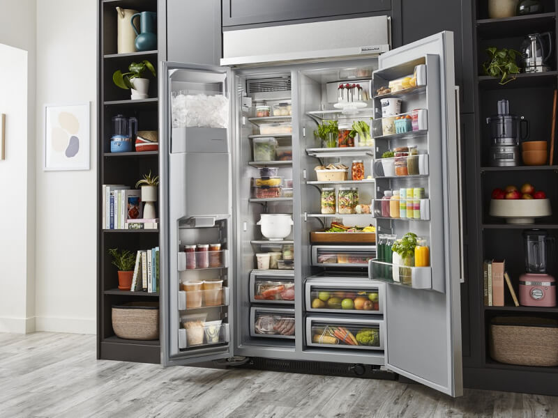 An open side-by-side refrigerator, full of colorful food items