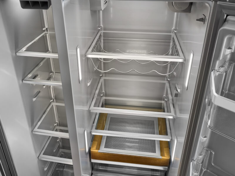 Empty KitchenAid® side-by-side refrigerator with a wine rack 