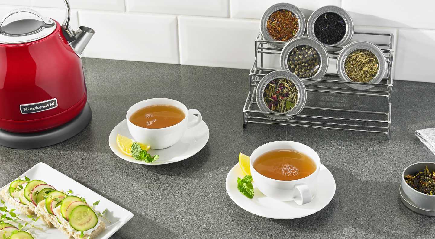 Two cups of tea on saucers with lemon and mint
