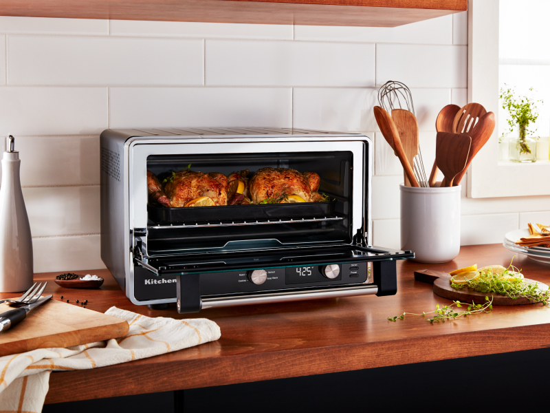 Two whole chickens roasting in a KitchenAid® countertop oven