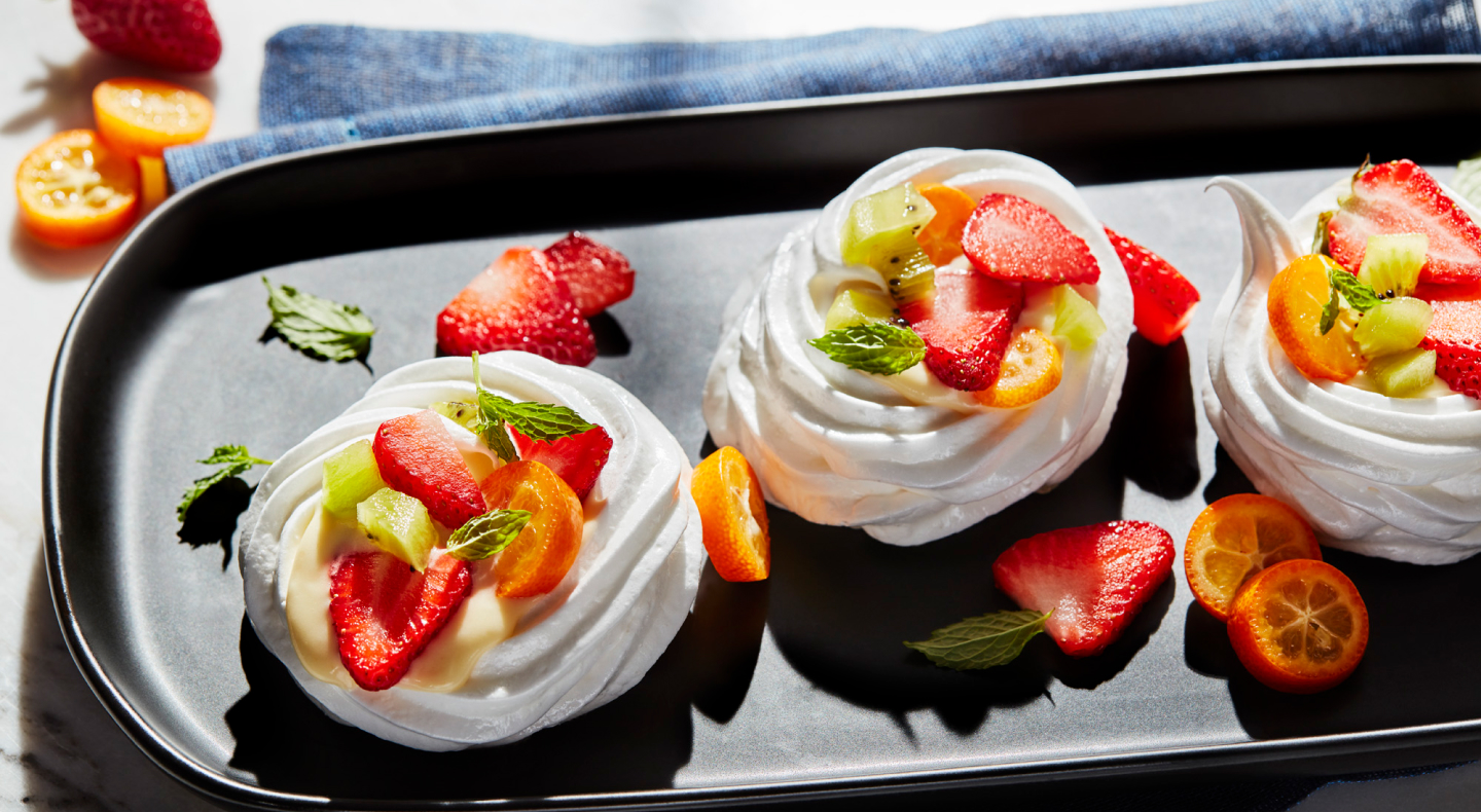 Mini pavlovas topped with sliced fruit