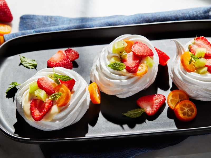 Mini pavlovas topped with sliced fruit