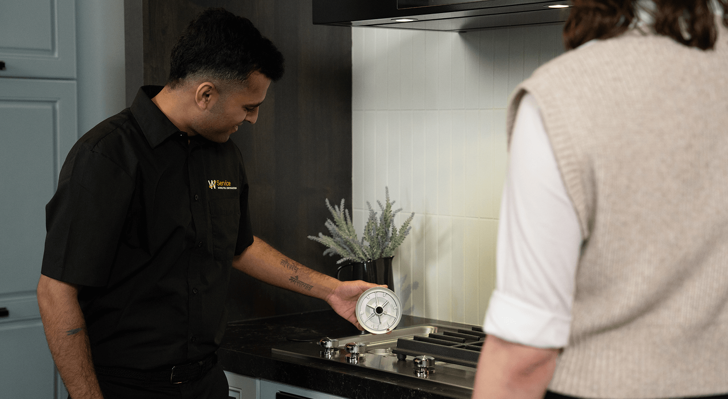 A technician helps someone with their cooktop