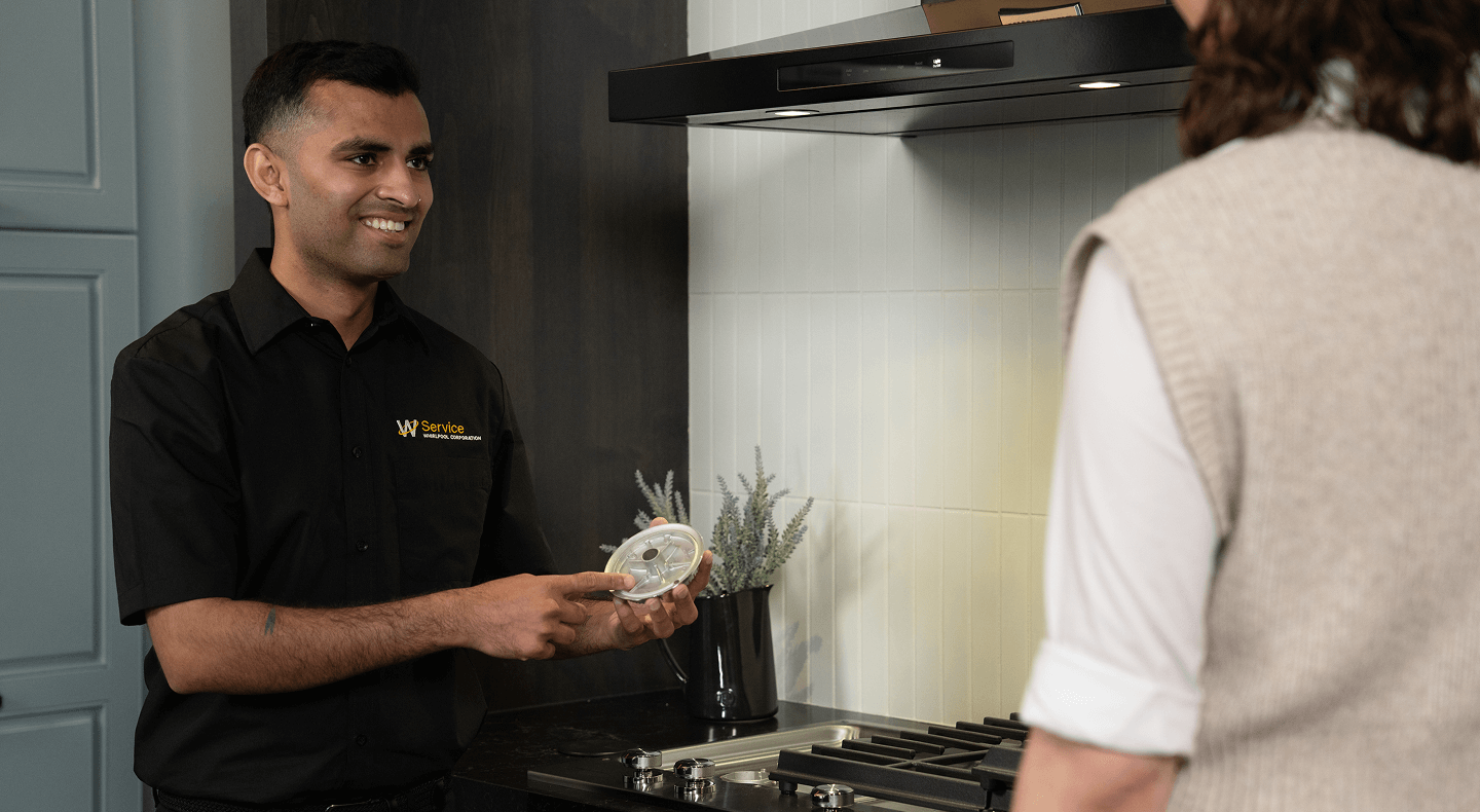A technician helps someone with their cooktop