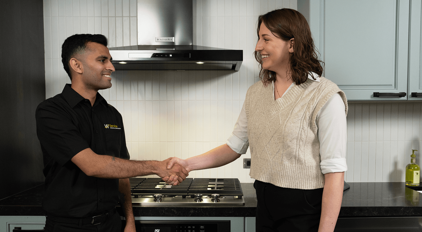 A technician helps a person in their kitchen