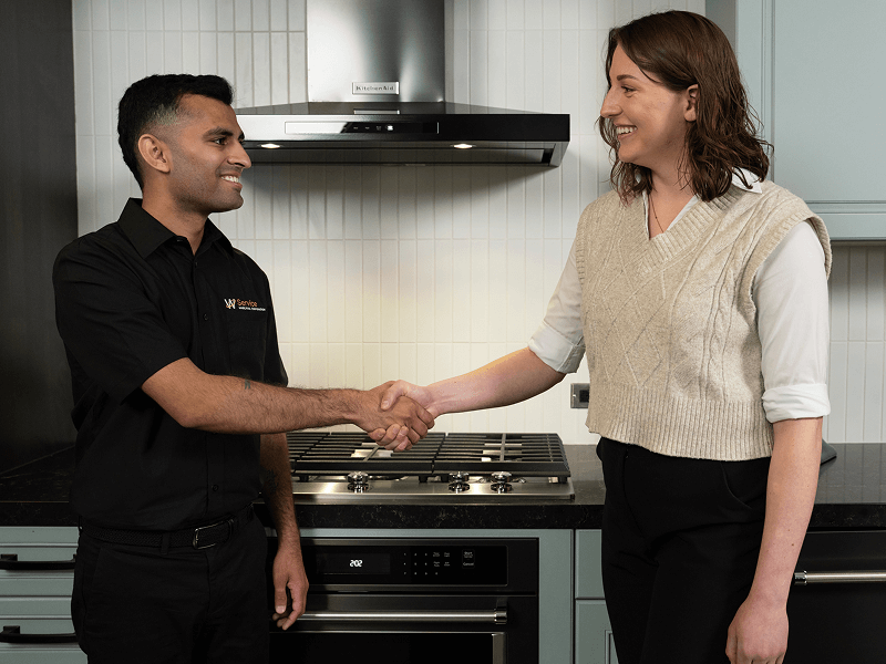 A technician helps a person in their kitchen