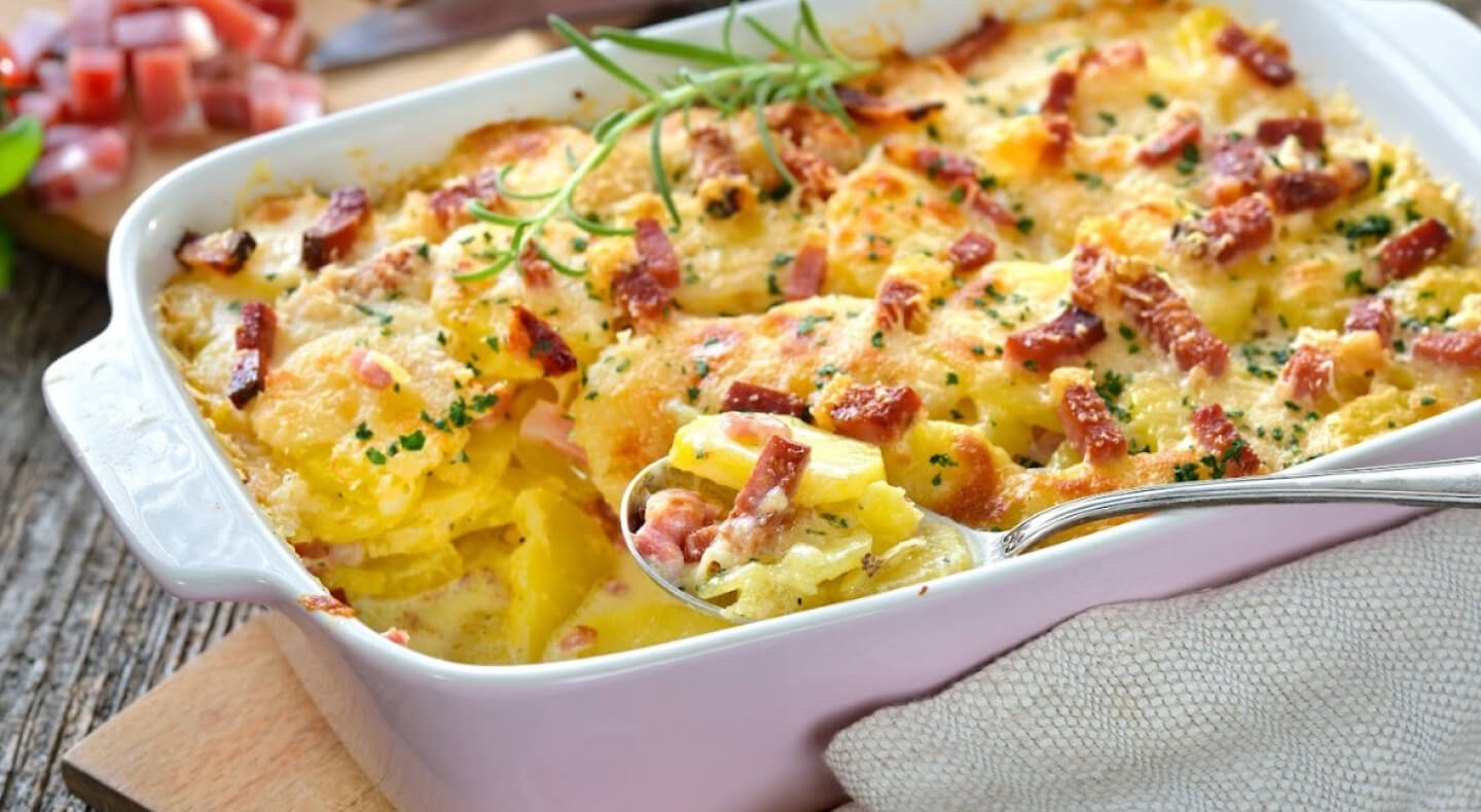 Spoon in an au gratin dish inside a white casserole pan