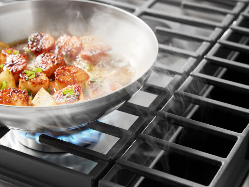 Downdraft hood sucking up smoke from scallops cooking on a downdraft gas range 
