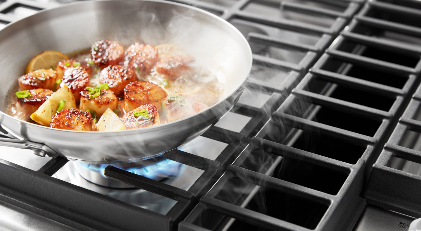 Downdraft hood sucking up smoke from scallops cooking on a downdraft gas range 