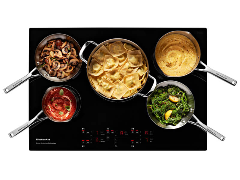 Overhead view of an induction cooktop surface with food